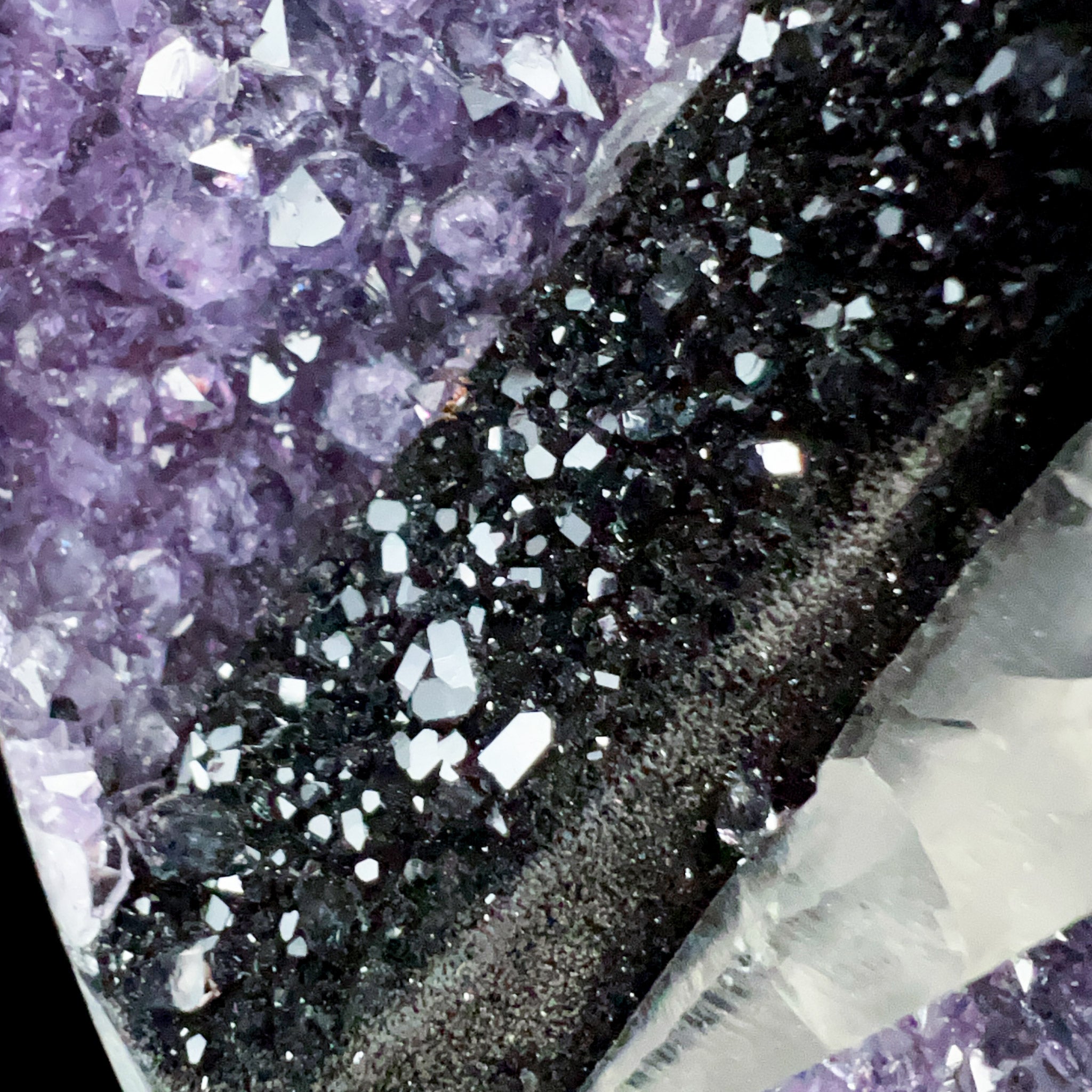 Black Hematite Mineral Specimen on top of White Calcite Crystals and Amethyst Crystals