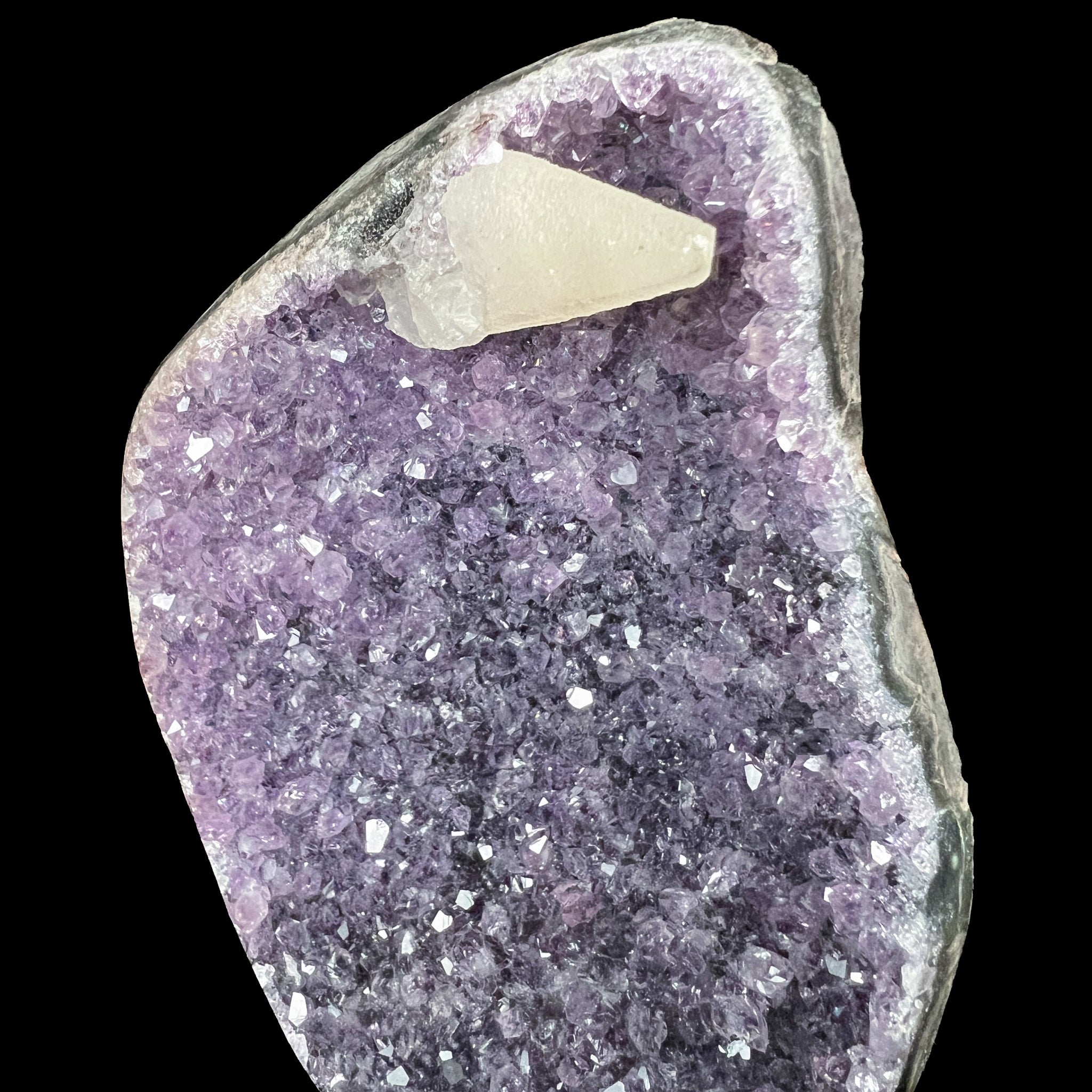 Dogtooth Calcite crystal on purple Amethyst crystals
