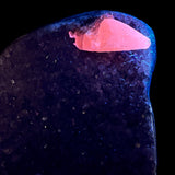 Calcite crystal fluorescing pink under UV light