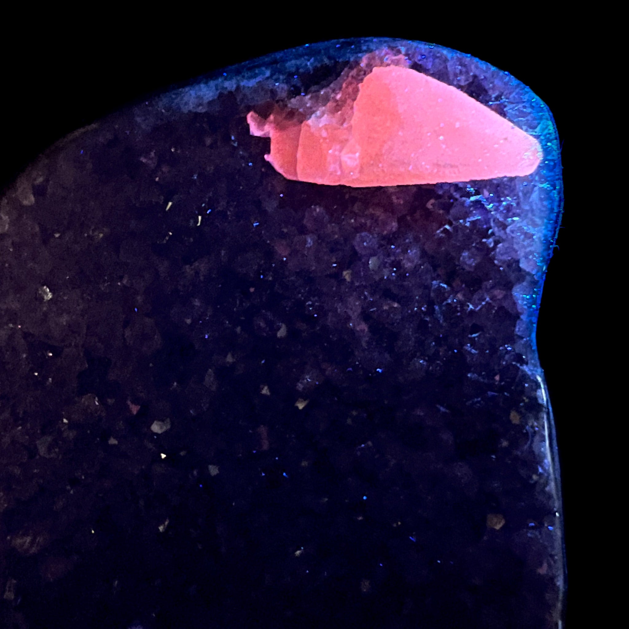 Calcite crystal fluorescing pink under UV light