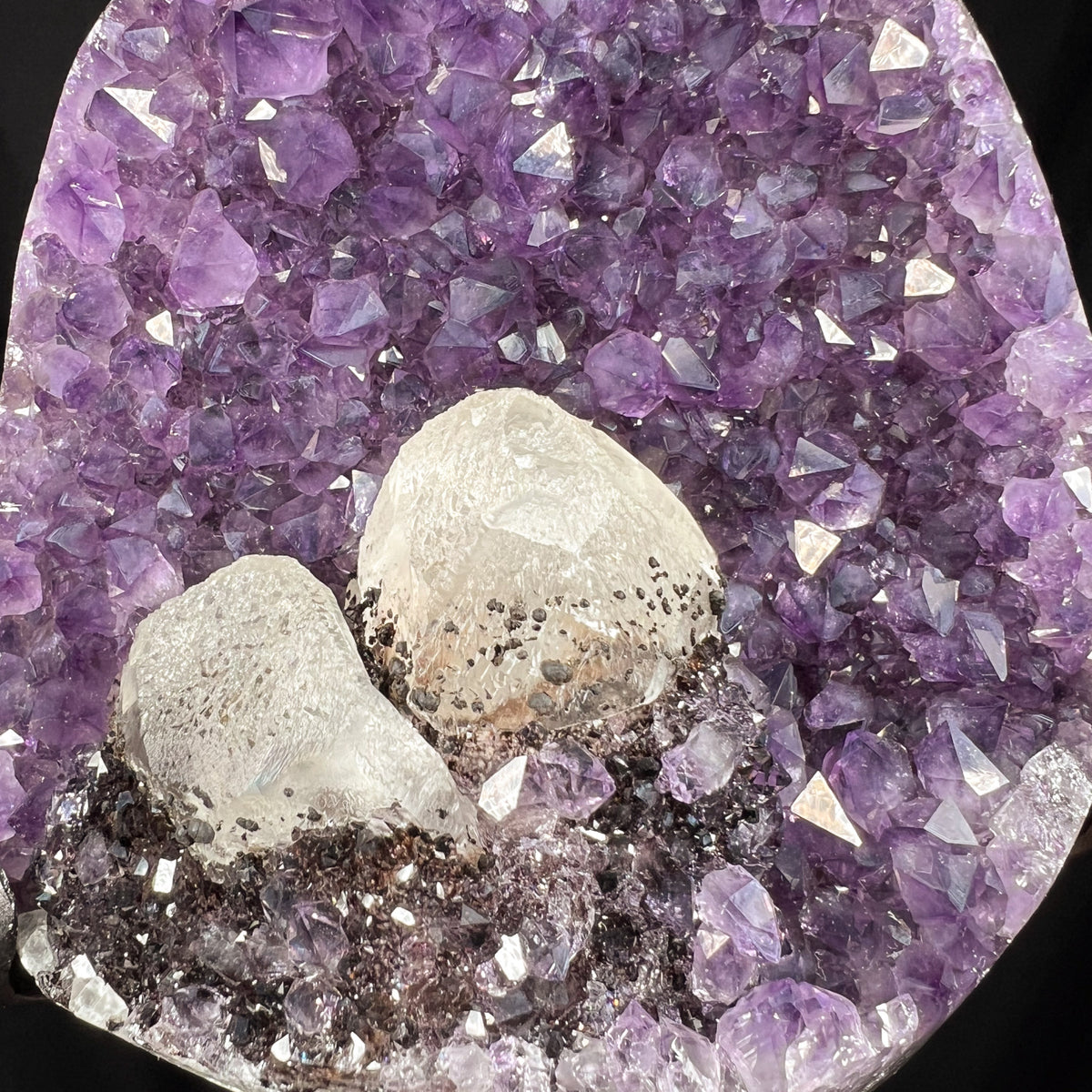 Close Up of Calcite and Hematite Crystals growing inside Amethyst geode
