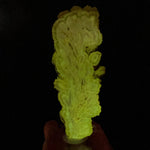 Barite crystal slice displaying phosphorescence under UV flashlight exposure