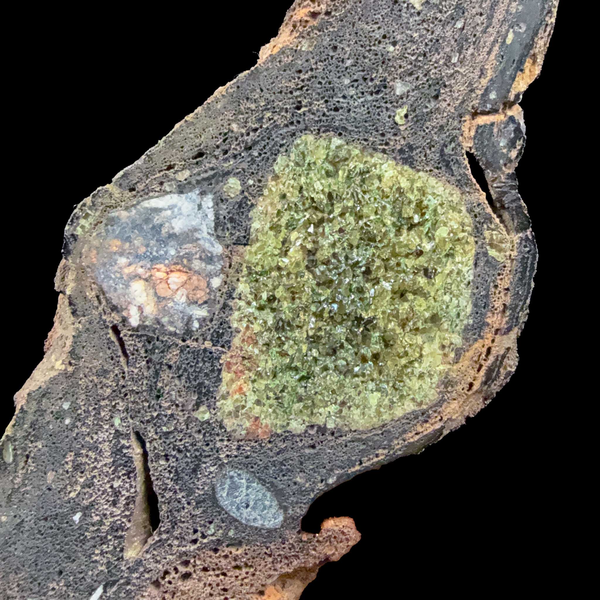 Close up of green olivine crystals inside a volcanic rock ejected from a volcano