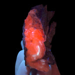 Calcite specimen fluorescing under UV light exposure