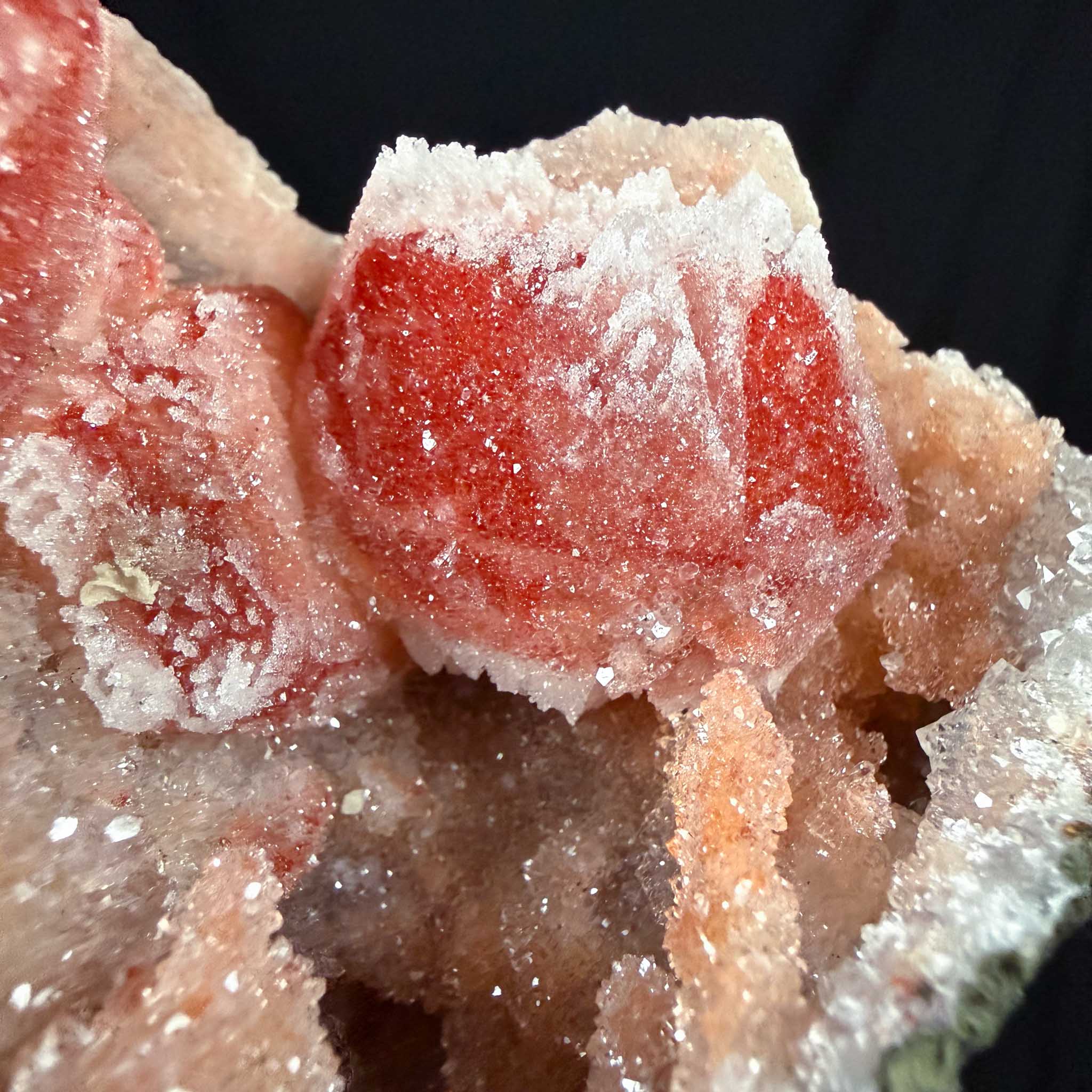 Close up of iron-included red Calcite crystal coated by Drusy Quartz