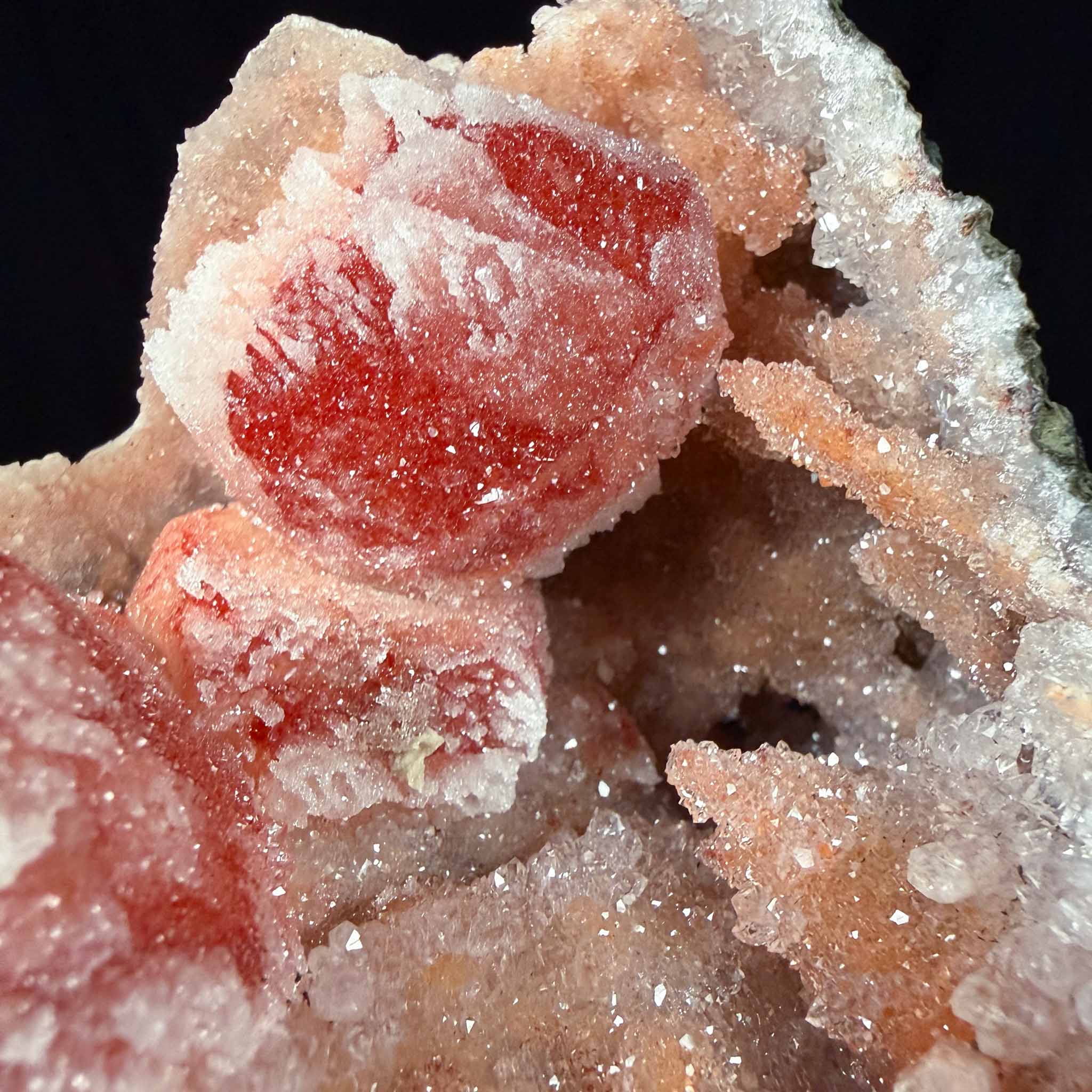 Close up of red and orange Calcite crystals coated with Drusy Quartz inside a Geode