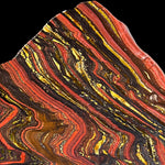 Close-up of a colorful,  red, yellow, and black banding patterns of Tiger Iron stone