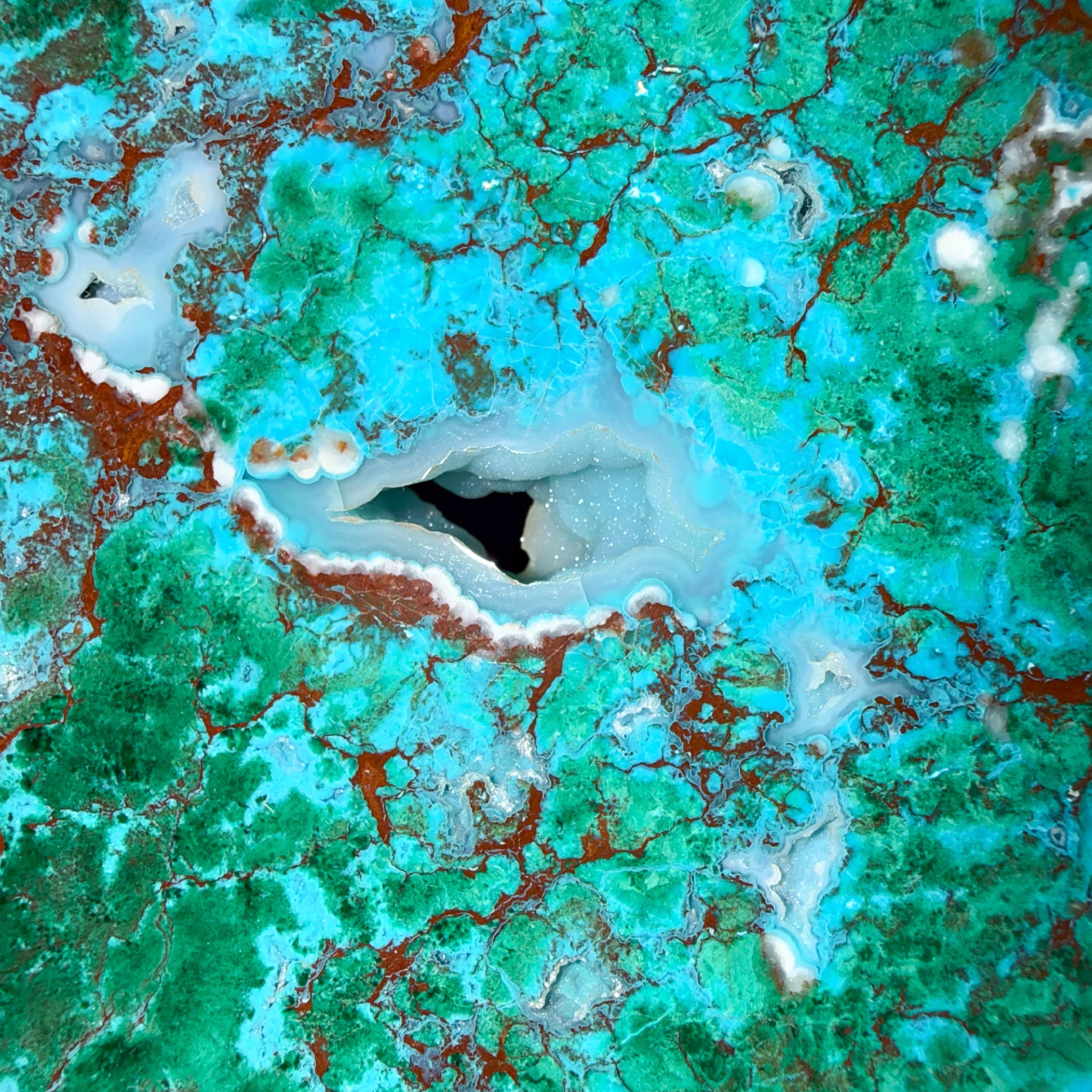 Close up of chrysocolla and quartz crystal pocket in stone slice from Australia